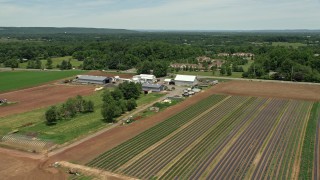 AX83_001 - 4.8K aerial stock footage of a farm and crop field by a country road, Skillman, New Jersey