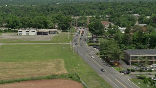AX83_032 - 4.8K aerial stock footage of light traffic on State Road beside a green field and abandoned building, Princeton, New Jersey