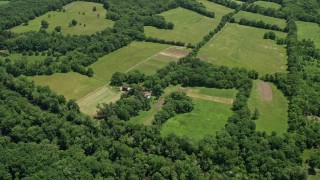 AX83_033 - 4.8K aerial stock footage of a farmhouse, barn, and green fields in Belle Mead, New Jersey