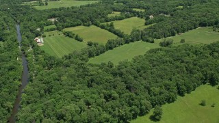 AX83_034 - 4.8K aerial stock footage flying over farm fields with barns by the Millstone River in Belle Mead, New Jersey
