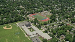 AX83_063 - 4.8K aerial stock footage flying by school and sports fields in a suburban neighborhood, Westfield, New Jersey