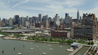 AX83_151E - 4.8K aerial stock footage flying by Starrett-Lehigh Building and Hudson Yards, land at heliport, with a view of Midtown Manhattan skyscrapers, New York City