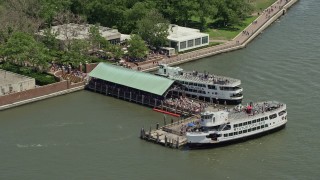 AX83_196 - 4.8K aerial stock footage of crowds of tourists at the ferry dock on Liberty Island, New York