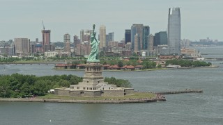 AX83_198E - 4.8K aerial stock footage zooming in on Statue of Liberty overlooking New York Harbor, New York