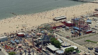 AX83_217 - 4.8K aerial stock footage of the Ferris wheel at Luna Park and beach goers on Coney Island Beach, Brooklyn, New York City