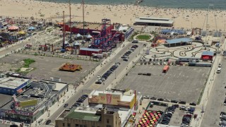 AX83_218E - 4.8K aerial stock footage orbiting Luna Park and tilt to reveal Original Nathan's Famous Hot Dogs, Coney Island, Brooklyn, New York City