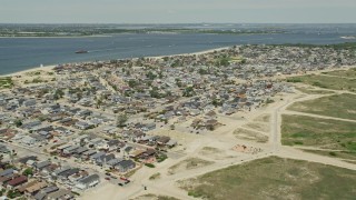 AX83_224 - 4.8K aerial stock footage flying by residential neighborhoods near the water, Breezy Point, Queens, New York