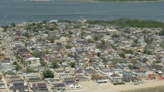 AX83_225 - 4.8K aerial stock footage of a residential neighborhood near the water, Breezy Point, Queens, New York