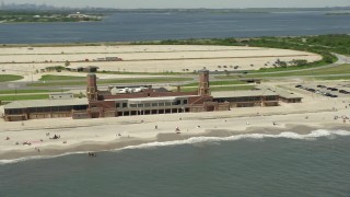 AX83_227 - 4.8K aerial stock footage of beachgoers at Jacob Riis Park in Queens, New York