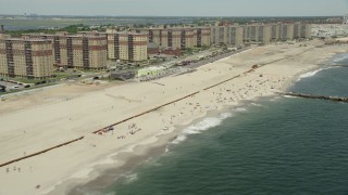 AX83_229 - 4.8K aerial stock footage of beach goers and apartment complexes, Rockaway Beach, New York 