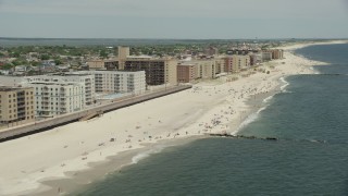 AX83_242 - 4.8K aerial stock footage tilting to a Crowd of Sunbathers on the Beach, Long Beach, New York