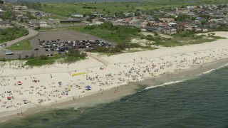 AX83_244 - 4.8K aerial stock footage of sunbathers enjoying the beach and the Ocean, Lido Beach, New York