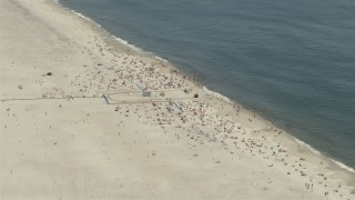AX83_252 - 4.8K aerial stock footage approaching and flying over a small crowd at Jones Beach State Park, Wantagh, New York