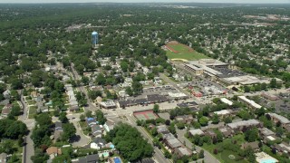 AX83_260E - 4.8K aerial stock footage flying over suburban neighborhoods near a high school in Massapequa, New York