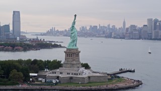 AX84_003E - 4K aerial stock footage of flying by the Statue of Liberty, New York, New York