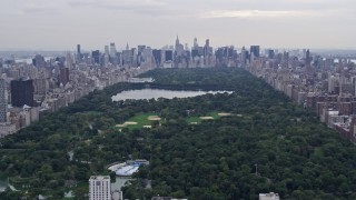 AX84_039E - 4K stock footage aerial video tilt from Harlem row houses, revealing Central Park, New York City