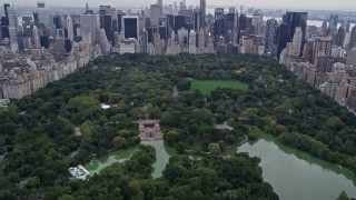 AX84_044E - 4K stock footage aerial video tilt from Central Park, reveal and approach Midtown skyscrapers, New York City