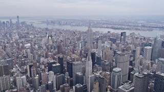 AX84_070E - 4K aerial stock footage of tilt from Midtown buildings to reveal and approach Chrysler Building, Empire State Building, New York City