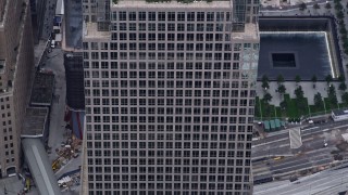 AX84_091E - 4K aerial stock footage tilt down the side of Freedom Tower, reveal the Memorial in Lower Manhattan, New York City