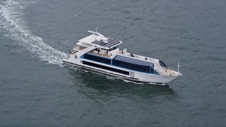 AX84_110E - 4K aerial stock footage of a ferry on Hudson River, tilt to reveal Lower Manhattan skyscrapers, New York City