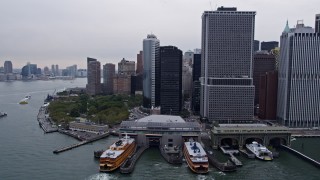 AX84_159E - 4K aerial stock footage flyby 1 New York Plaza, Staten Island Ferry and Battery Park in Lower Manhattan, New York City