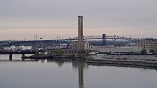 AX84_174E - 4K aerial stock footage of approaching a waterfront factory in Newark, New Jersey