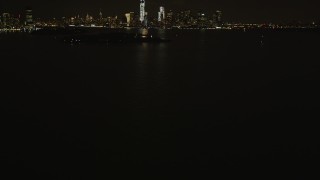 AX85_002 - 4K aerial stock footage Revealing Statue of Liberty, Lower Manhattan skyline, New York, New York, night