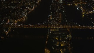 AX85_100 - 4K aerial stock footage Approaching the Queensboro Bridge, tilt down, New York, New York, night