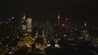 AX85_113 - 4K aerial stock footage Flying by Midtown Manhattan, revealing West Side Yard, New York, New York, night
