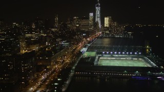 AX85_117 - 4K aerial stock footage Tilt up from piers, Chelsea, Lower Manhattan, New York, New York, night
