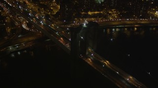 AX85_128 - 4K aerial stock footage Flying by the Brooklyn Bridge, New York, New York, night