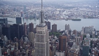 AX86_059 - 4K aerial stock footage of a reverse view of the Empire State Building in Midtown Manhattan, New York City
