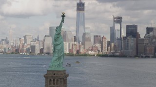 AX87_011 - 4K aerial stock footage Flying by Statue of Liberty, revealing Lower Manhattan skyline, New York, New York