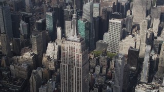 AX87_112 - 4K aerial stock footage Flying by top of Empire State Building, Midtown Manhattan skyscrapers, New York
