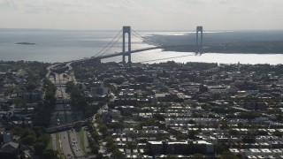 AX88_030 - 4K stock footage aerial video of the Verrazano-Narrows Bridge, seen from Brooklyn row houses, New York