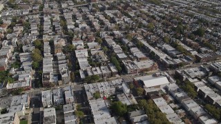 AX88_032 - 4K stock footage aerial video of flying over row houses, tilt up to wider view, Brooklyn, New York