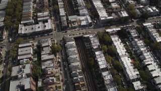 AX88_039 - 4K aerial stock footage of following railroad tracks through an urban neighborhood, Brooklyn, New York
