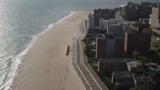 AX88_061 - 4K aerial stock footage of flying by Coney Island Beach and boardwalk in Brooklyn, New York, New York