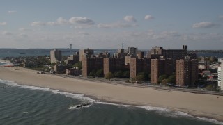 AX88_064 - 4K aerial stock footage of beachfront apartment buildings by Coney Island Beach, Brooklyn, New York