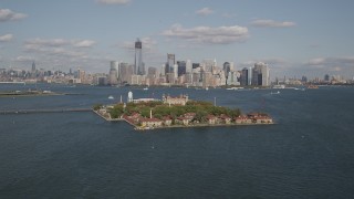 AX88_111 - 4K aerial stock footage of flying by Ellis Island, Lower Manhattan skyline in background, New York, New York