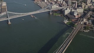 AX88_121 - 4K aerial stock footage pan from Manhattan Bridge to famous Brooklyn Bridge, East River, New York, New York