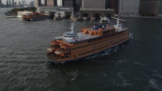 AX88_162 - 4K aerial stock footage of orbiting the Staten Island Ferry leaving the Lower Manhattan terminal, New York