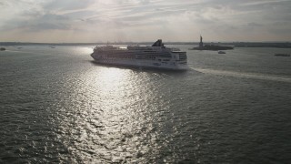 AX88_191 - 4K aerial stock footage of flying by cruise ship sailing near the Statue of Liberty, New York