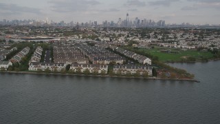 AX88_202 - 4K aerial stock footage of flying by waterfront condominiums, Lower Manhattan skyline in background, Jersey City, New Jersey