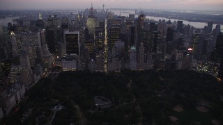AX89_091 - 4K stock footage aerial video Approaching Central Park, revealing Midtown Manhattan, New York, twilight
