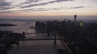 AX89_105 - 4K aerial stock footage of the Brooklyn Bridge, Manhattan Bridge, East River, Lower Manhattan, New York, twilight