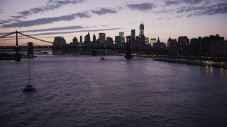 AX89_120 - 4K aerial stock footage Flying over East River, Lower Manhattan, Manhattan Bridge, New York, twilight