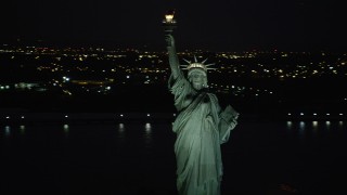 AX89_148 - 4K aerial stock footage Flying by Statue of Liberty, New York Harbor, New York, New York, night
