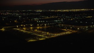 AX89_150 - 4K aerial stock footage Approaching a parking garage, tilt down, Jersey City, New Jersey, night