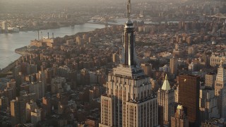 AX90_061 - Aerial stock footage of Flying by Empire State Building, Midtown Manhattan, New York, sunrise